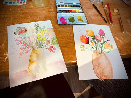 Zwei Aquarelle von Blumenvase auf Tisch.