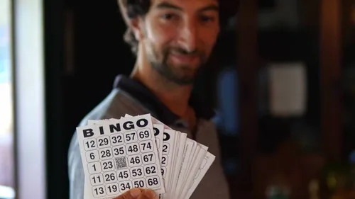 Man holding bingo cards indoors.