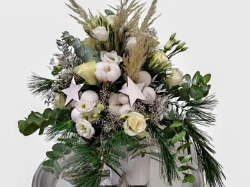Blumenstrauß wirkt festlich, dekoriert mit Sternen und Pflanzen.