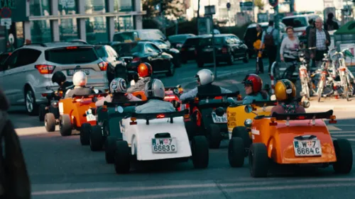 Group driving miniature cars in urban street.