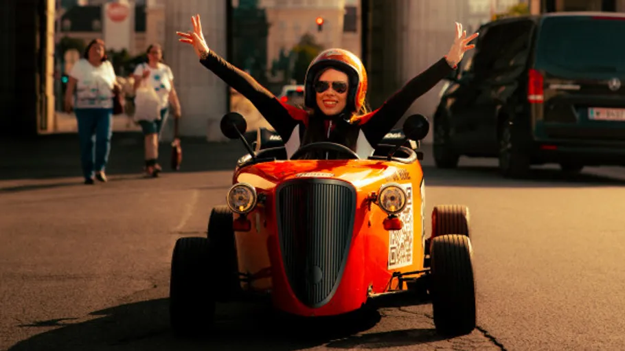 Woman driving small vintage car joyfully.
