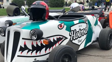 Customized hot rod car with shark design parked.