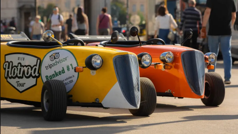 Two colorful mini cars parked in a city.