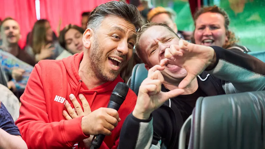 Two people singing on a cheerful bus.