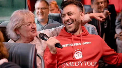 Woman and man laughing on a tour bus.