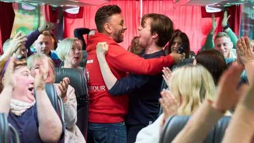 People excitedly singing on a bus.
