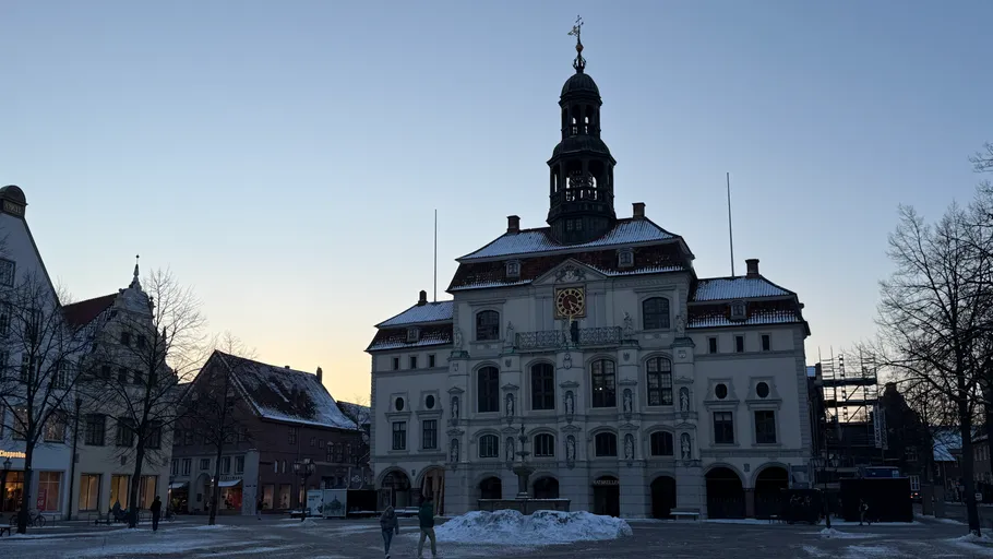 Historic building in snowy town square at dusk.