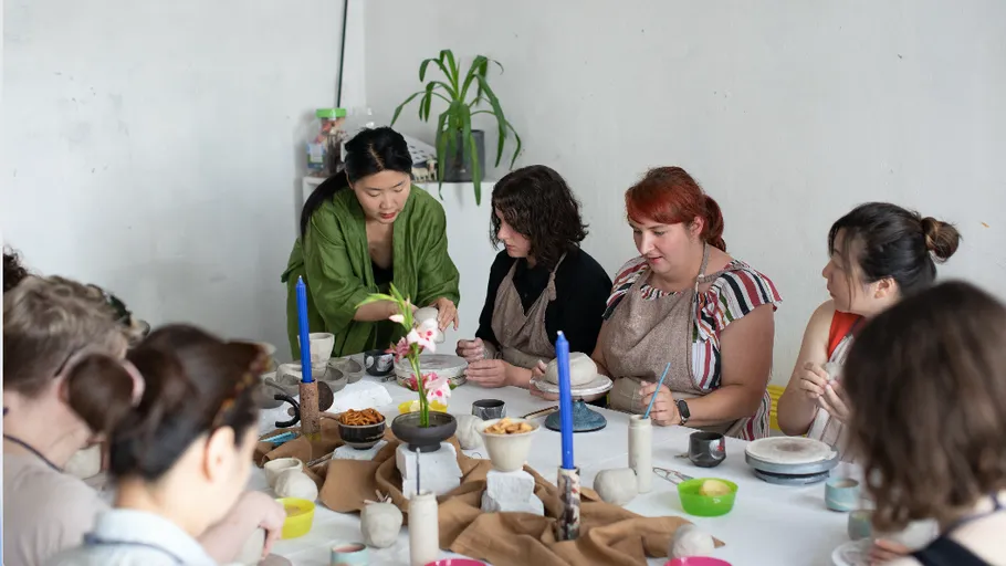People in a workshop creating clay art pieces.