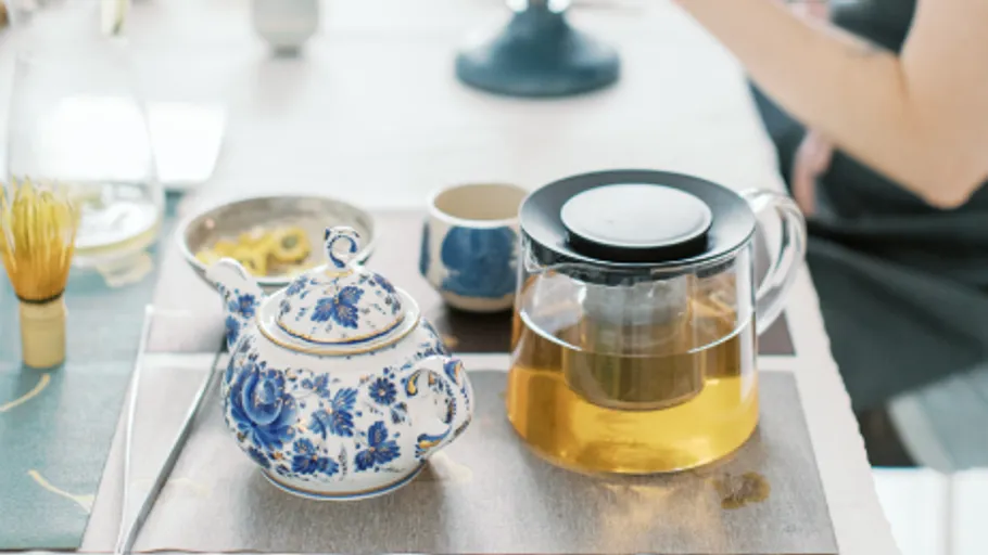 Teekanne und Glasteekanne auf Esstisch.