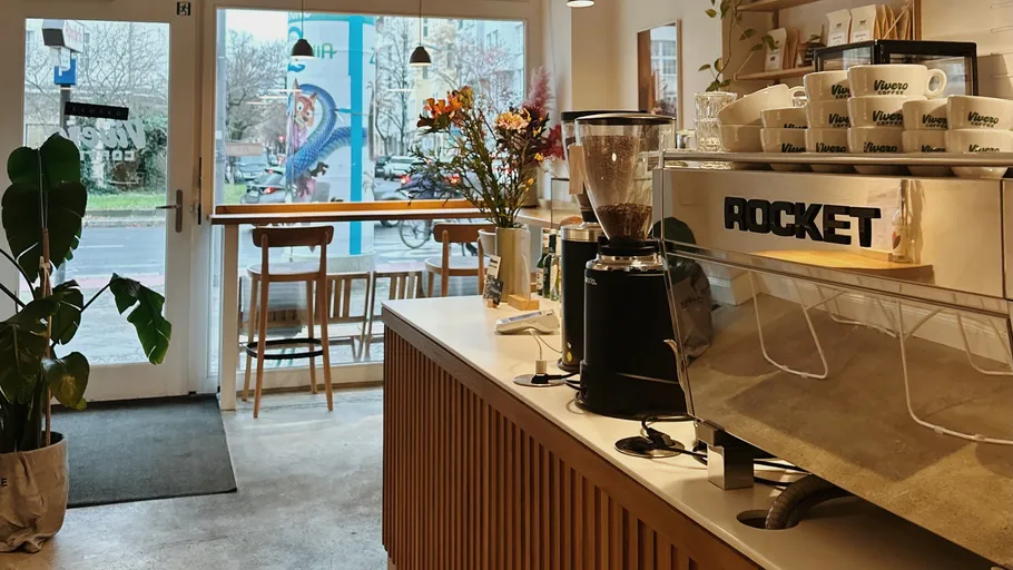 Coffee shop interior with espresso machine and seating.