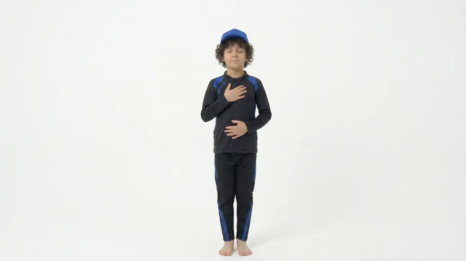 Child meditating with eyes closed indoors.