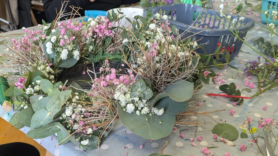 Blumenkranz wird auf Tisch hergestellt.