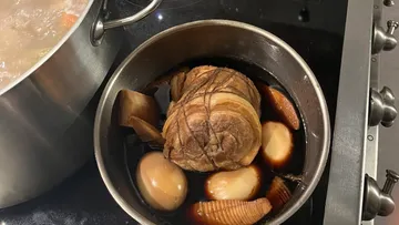 Rolled pork with eggs in soy sauce, cooking.