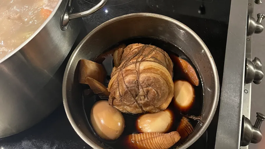 Gerollter Schweinebraten mit Eiern in Sojasauce, kochend.