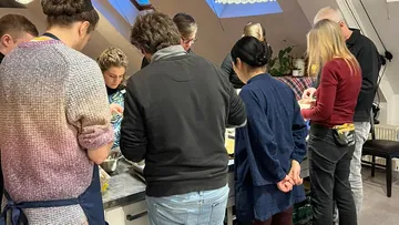 Gruppe kocht zusammen in einer Küche.