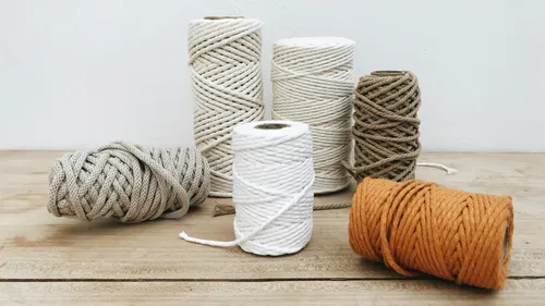 Colorful yarn spools on a wooden table.