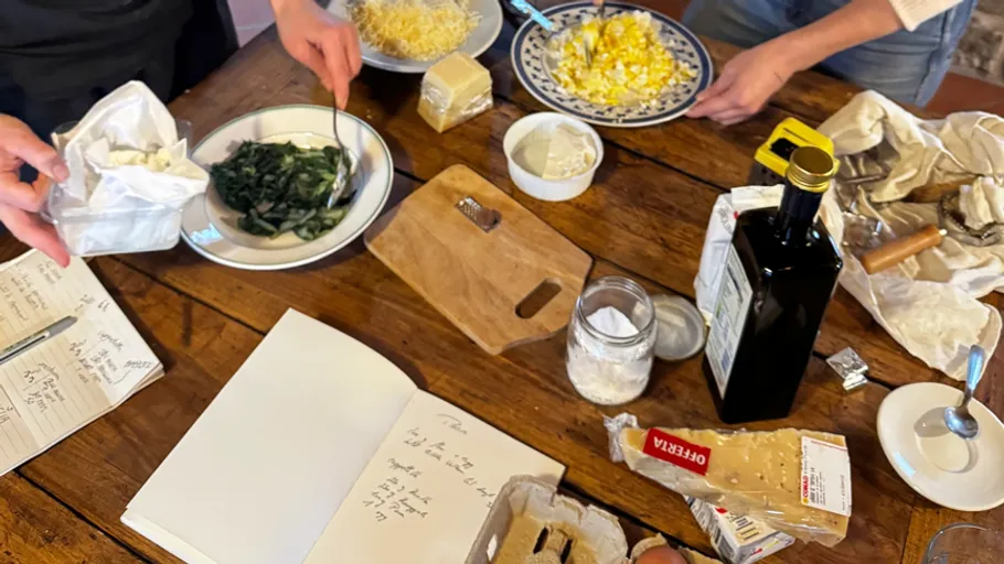People preparing food with various ingredients on table.