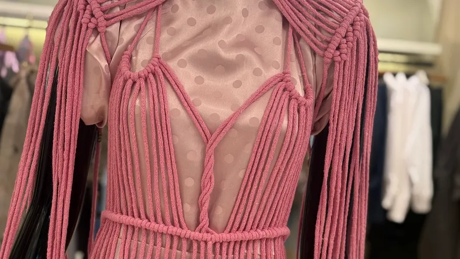 Pink macramé dress in fashion display.