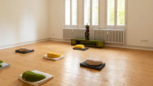 Meditationskissen auf Holzboden angeordnet.