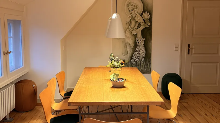 Wooden dining table with chairs in cozy room.