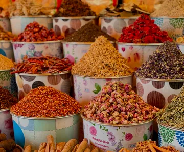 Bunte Gewürze in Marktbehältern ausgestellt.