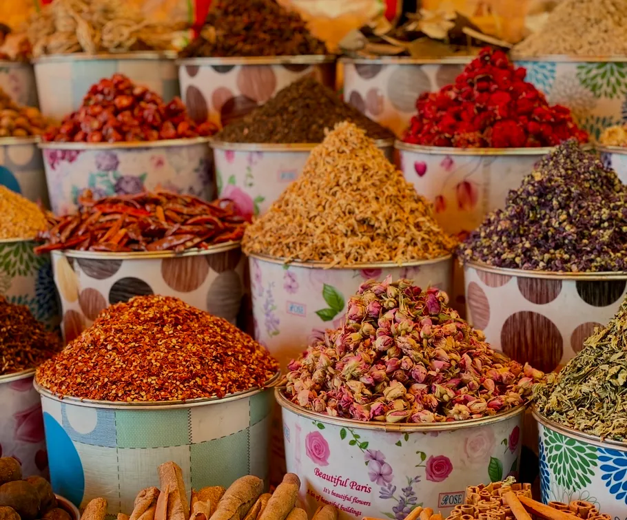 Bunte Gewürze in Marktbehältern ausgestellt.