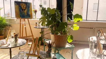 Kunststudio mit Staffeleien, Gemälde und Pflanzen.