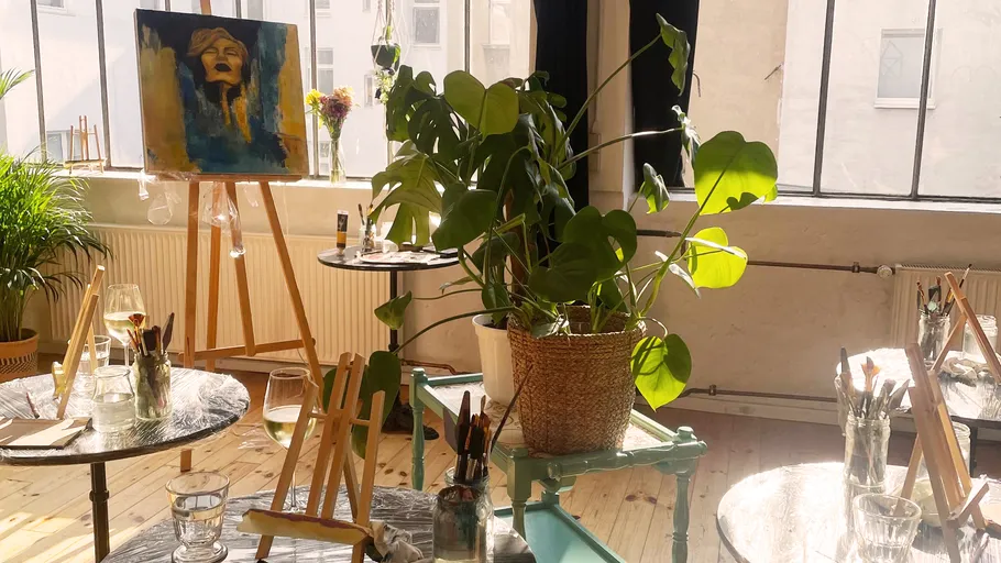 Kunststudio mit Staffeleien, Gemälde und Pflanzen.