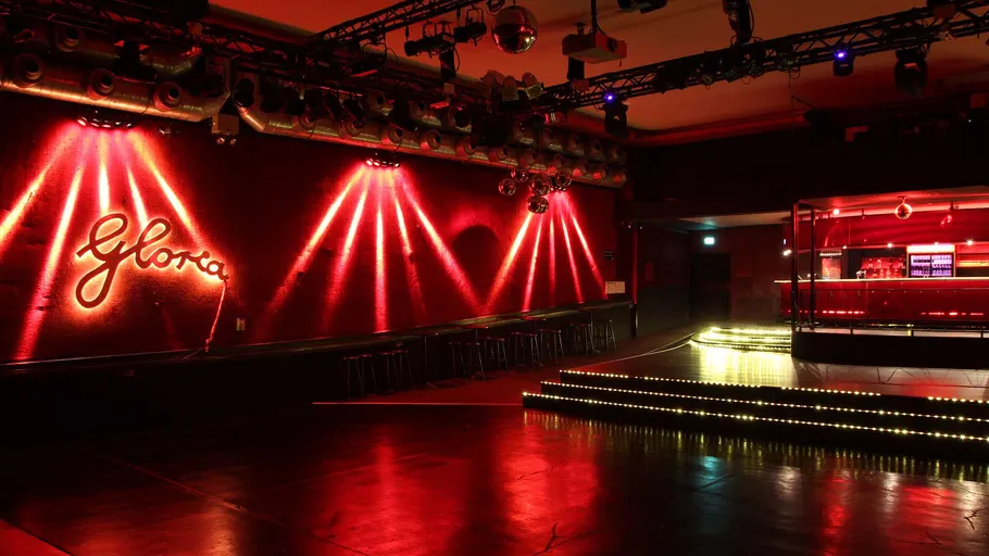 Leerer Nachtclub mit roten Lichtern und Bar.