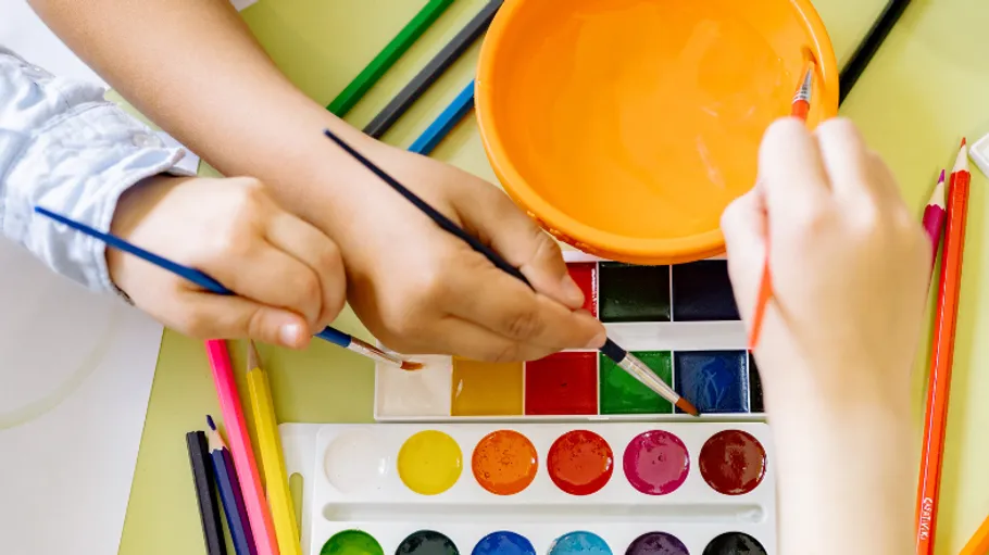 Children painting with brushes and watercolors.