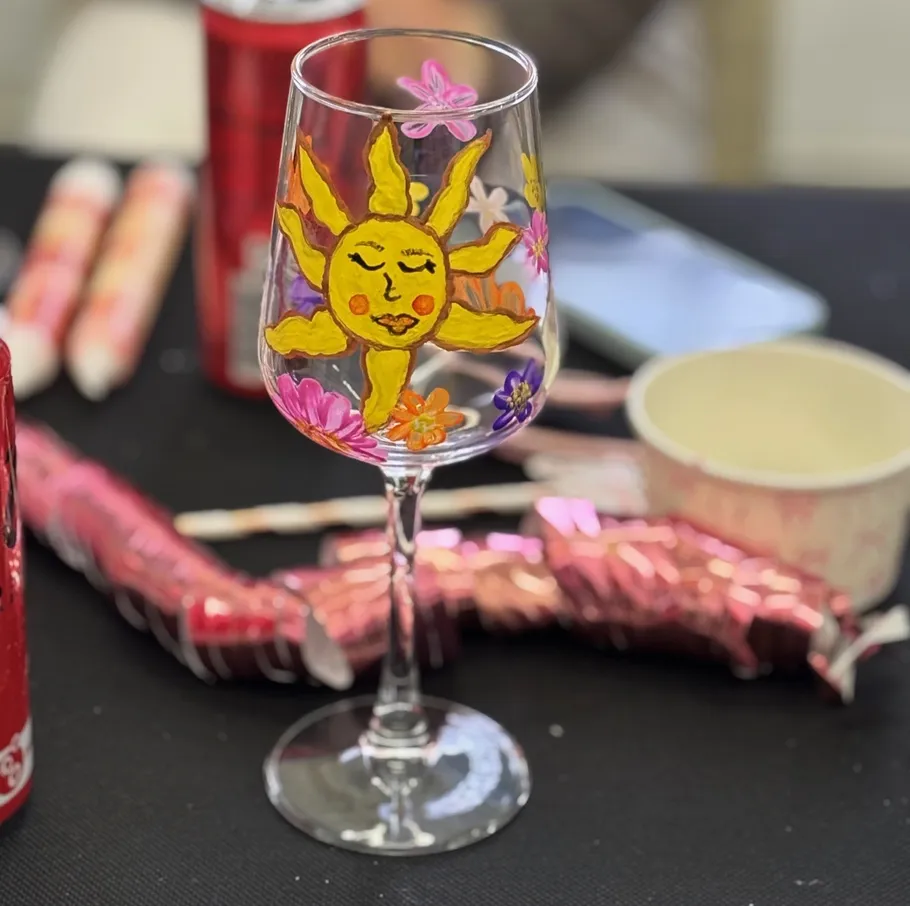 Decorated wine glass with a sun design.