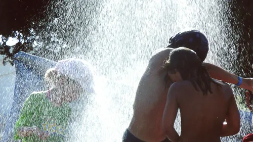 Children playing in water spray outdoors.