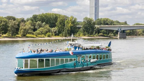 Blue tour boat cruising on river.