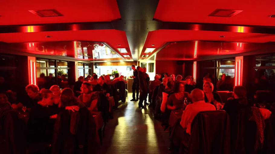 Menschen essen in schwach beleuchtetem Restaurant.