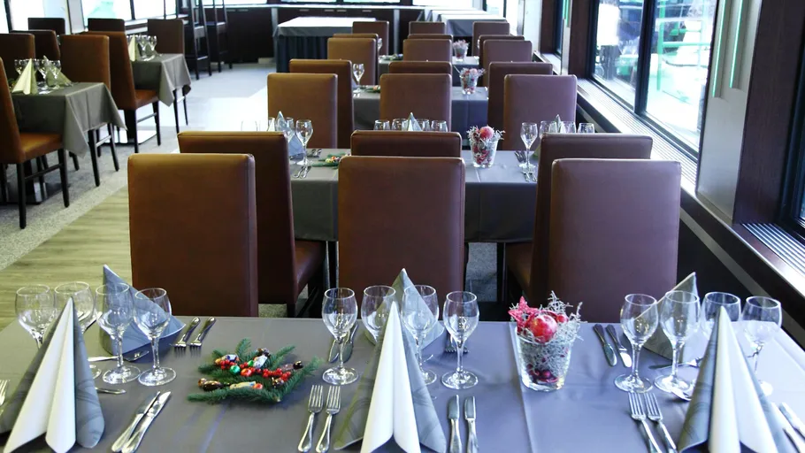 Elegant restaurant table settings with brown chairs.