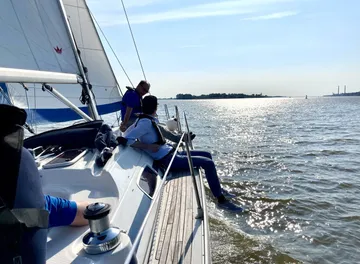 People sailing on a boat in sunlight.