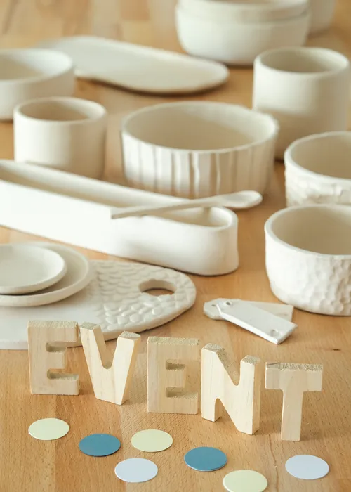 Wooden letters spell 'EVENT' on wooden table.
