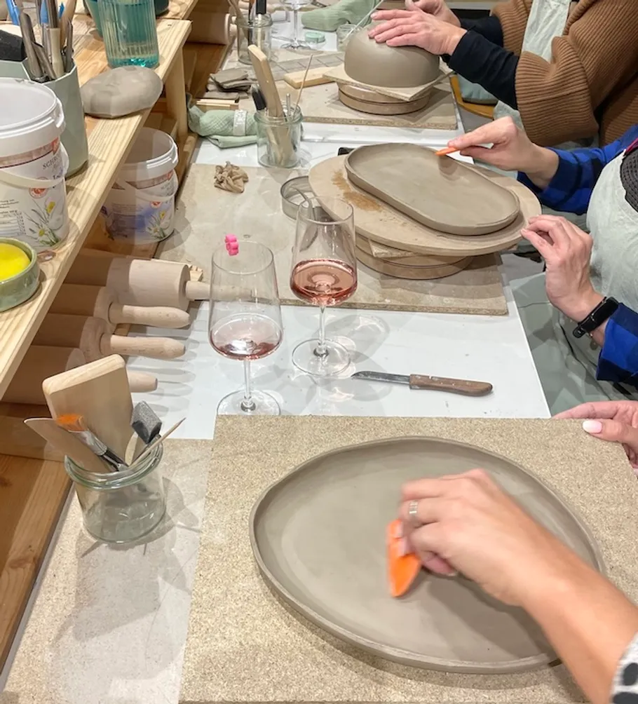 People shaping clay at a pottery class.