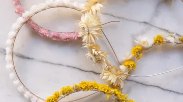 Getrocknete Blumenkränze auf Marmoroberfläche.