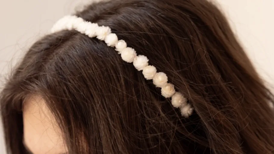 Weißes Stirnband auf braunem Haar.