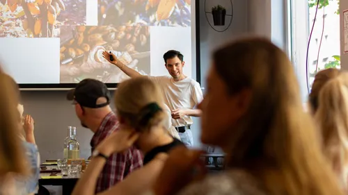 Man presenting to attentive audience in cafe.