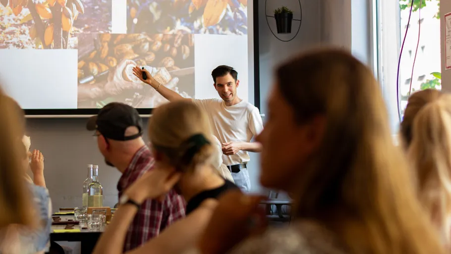 Man presenting to attentive audience in cafe.