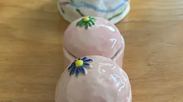 Keramik-Teekannen-Deckel mit Blumenmuster, auf Holz.