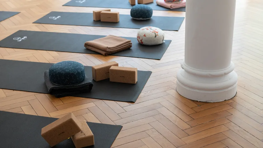 Yogamatten mit Kissen in hellem Studio.