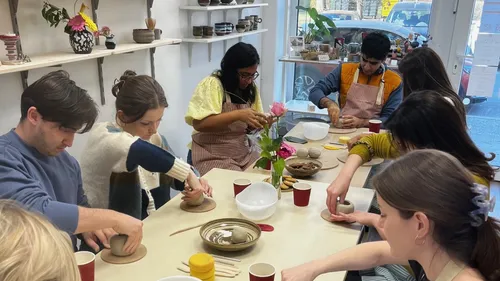 People crafting pottery in a workshop.