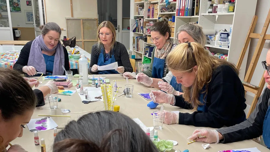 People painting together at a workshop table.