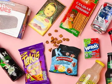 Vielfalt an Snacks liegt auf pinkem Hintergrund verteilt.