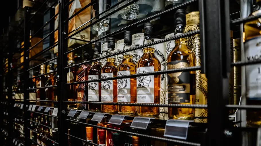 Whiskeyflaschen hinter einem Metallgitter ausgestellt.