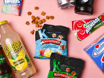 Getränke und Snacks liegen verstreut auf pinkem Untergrund.
