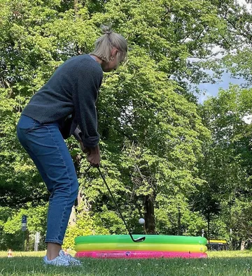 Person spielt Golf mit Kinderpool-Ziel.